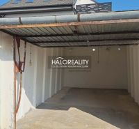 Eine leere Garage in Senec mit Überdachung und weißen Wänden.