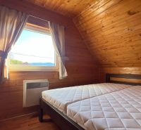 Ein Zimmer mit Holzeinrichtung, einem Bett und einem Ausblick aus dem Fenster in der Hütte.