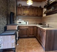 Küche in einer Hütte mit Holzdekor und Herd, Kombination aus Holz und Stein.
