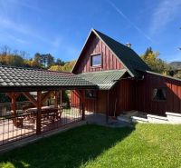 Eine Hütte in Turík, Bezirk Ružomberok, Region Žilina mit einer Holzterrasse und einem Garten.
