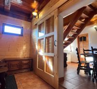 Innenraum aus Holz mit Esstisch, Treppe und Holzwanddekoration.