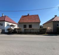 Ein Einfamilienhaus in Banská Bystrica mit rotem Dach und einem Strauchzaun.