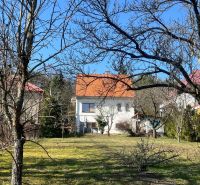 Ein Einfamilienhaus in Podhájska, Kráľová, umgeben von Bäumen und Rasen, mit einem orangefarbenen Dach.