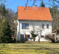 Ein Einfamilienhaus in Kráľová, Banská Bystrica, mit einem roten Dach, umgeben von Grün und Bäumen.