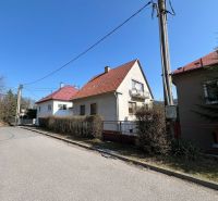 Einfamilienhaus in Podháj, Kráľová, Banská Bystrica. Schmaler Gehweg, Sträucher, Strommast.
