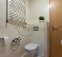 Badezimmer mit Keramikfliesen, Toilette und Heizkörper in einem Einfamilienhaus.