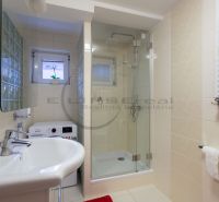 Badezimmer mit Toilette, Duschkabine und Waschmaschine in einem Einfamilienhaus.