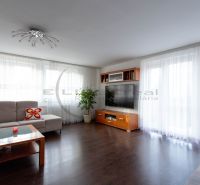 Wohnzimmer in einem Einfamilienhaus mit Holzboden und großen Fenstern.