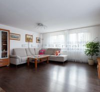 Wohnzimmer in einem Einfamilienhaus mit Sofa, Fernseher und Holzboden.