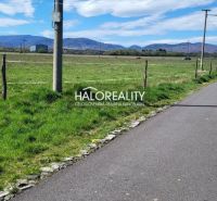 Asphaltstraße in Lutila, umgeben von grünen Wohngebieten mit Blick auf die Berge.