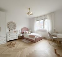 Kinderzimmer mit Holzboden, rosa Bett und Spielzeug in einem Einfamilienhaus.