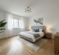 Helles Schlafzimmer in einem Einfamilienhaus mit Holzboden und Zimmerpflanze.