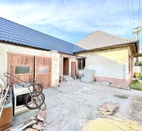 Ein Einfamilienhaus in Šoporňa mit zwei Dächern und einem ungepflegten Hof.