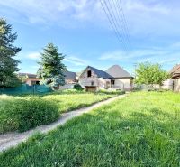 Baugrundstück in Šoporňa mit Blick auf die umliegende Grünfläche und Einfamilienhäuser.