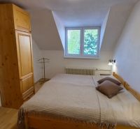 Schlafzimmer in einer 2-Zimmer-Wohnung mit Holzmöbeln und einem Boden mit Holzdekor.