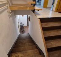 Eine Treppe in einer 2-Zimmer-Wohnung mit Holzdekor und einem Fahrrad am Eingang.
