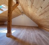 Dachbodenraum mit Holzverkleidung und Boden mit Holzdekor in einer 2-Zimmer-Wohnung.