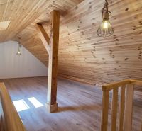 Dachbodenraum in einer 2-Zimmer-Wohnung mit Holzboden und Holzverkleidung.