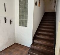 Ein Flur mit dunklen Treppen, die in die obere Etage einer 2-Zimmer-Wohnung führen.