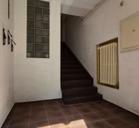 Flur der Treppe in einer 2-Zimmer-Wohnung mit Keramikfliesen und Treppen.