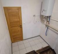 Eine Treppe mit Holzstufen und einem Gaskessel in einer 2-Zimmer-Wohnung.