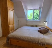 Schlafzimmer mit Holzmöbeln und Boden mit Holzdekor in einer 2-Zimmer-Wohnung.