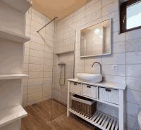 Badezimmer mit Keramikfliesen und Holzboden in einem Einfamilienhaus.