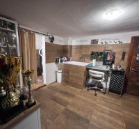 Ein Raum in einem Einfamilienhaus mit einem Stuhl, Trophäen und einem Boden mit Holzdekor.
