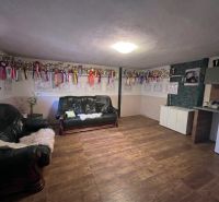 Innenraum eines Einfamilienhauses mit Sofa, Waschmaschine und Dekorationen von Auszeichnungen an der Wand.