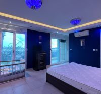 Schlafzimmer mit großem Bett, Kinderbett und Klimaanlage in einer Ferienwohnung.