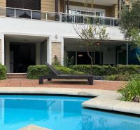 Ferienwohnung in Kumköy mit Terrasse, Pool, viel Grün und Liegestuhl.