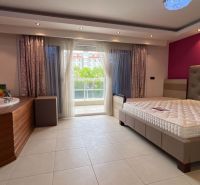 Ferienwohnung mit eingebauter Badewanne, Bett und Blick auf die Terrasse.
