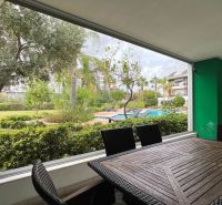 Ferienwohnung mit Terrasse, Blick auf den Pool und Garten.