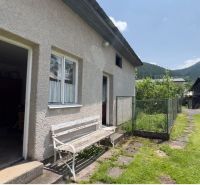 Ein Einfamilienhaus in Liptovská Lúžna mit einer Bank und einem malerischen Blick auf die Hügel.