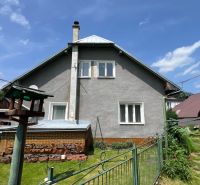 Ein Einfamilienhaus in Liptovská Lúžna mit einem gepflegten Garten und einem Vogelhäuschen.