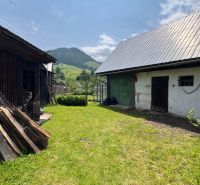 Ein Einfamilienhaus in Liptovská Lúžna mit Garten, Holzunterstand und Berglandschaft.