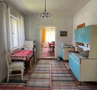 Innenraum eines Einfamilienhauses mit Küchenzeile, Esstisch und Holzboden-Dekor.