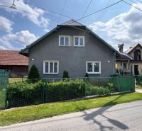 Ein Einfamilienhaus in Liptovská Lúžna mit Garten und Zaun an einem sonnigen Tag.