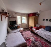 Ein Zimmer in einem Einfamilienhaus mit zwei Betten, einem Fernseher und einem Teppich.