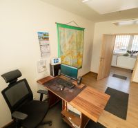 Ein Büro mit einem Tisch und einem Computer, ein Boden mit Holzdekor, besondere Immobilien.