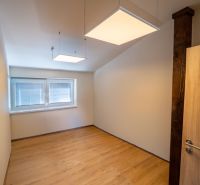 Ein Raum mit einem Boden in Holzdekor und quadratischen Leuchten, besondere Immobilien.