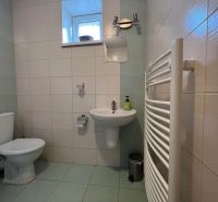Badezimmer in einer 2-Zimmer-Wohnung mit Toilette, Waschbecken und Heizkörper an der Wand.