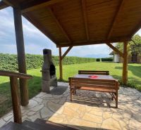 Überdachte Terrasse mit Sitzbereich und Außengrill bei der Hütte in Liptovská Sielnica.