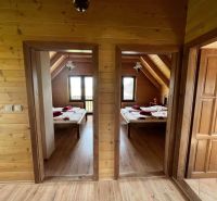 Innenraum einer Hütte mit zwei Schlafzimmern, Holzwänden und einem Boden mit Holzdekor.
