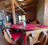 Holzsitzecke in einer Hütte mit Kamin und Boden in Holzoptik.