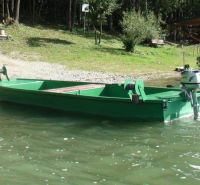 Ein grünes Boot auf dem Wasser am Ufer in Liptovská Sielnica, umgeben von Grün und Bäumen.