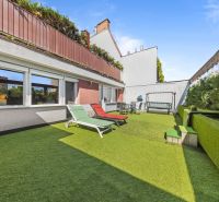 Eine Terrasse mit Kunstrasen und Liegestühlen bei einem Einfamilienhaus in Bratislava, Dúbravka auf der Talichova.