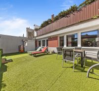 Die Terrasse des Einfamilienhauses in der Talichova-Straße in Bratislava - Dúbravka mit Kunstrasen.