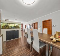 Esszimmer in einem Einfamilienhaus mit Aquarium und Boden in Holzoptik.