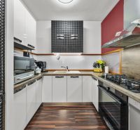 Küche im Einfamilienhaus mit modernen Geräten und Bodenbelag in Holzoptik.